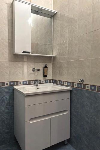 a bathroom with a white sink and a mirror at Hristean Apartment Petrich in Petrich