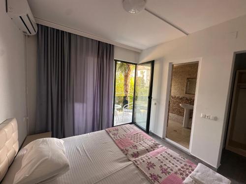 a bedroom with a bed and a large window at Hotel ARARAT in Gonio