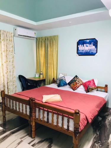 a bedroom with a bed with a red blanket at sarangvilla homestay varkala,edava in Kappil