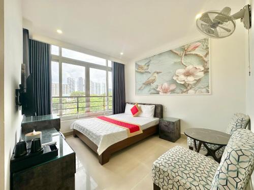 a hotel room with a bed and a chair at Phú Gia Hotel 464 Nguyễn Văn Linh in Ho Chi Minh City