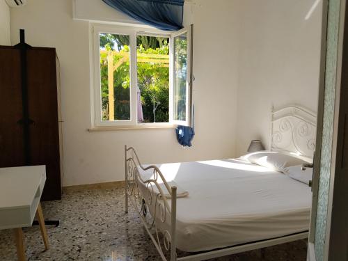 a bedroom with a white bed and a window at l'Araucaria casa vacanze in Marsala