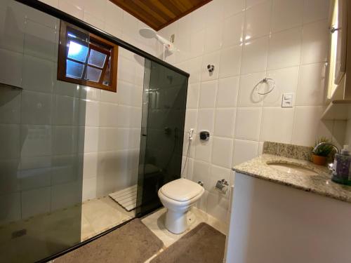 a bathroom with a toilet and a shower and a sink at Paz na Serra Teresopolis Pet Friendly in Teresópolis