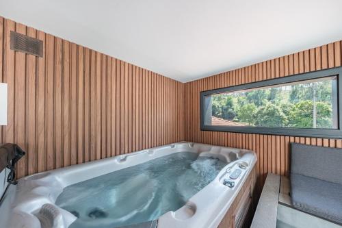 a large bath tub in a room with a window at Casa do primo Zeca in Ponte da Barca