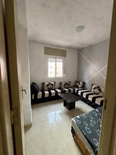a living room with a couch and a table at Perfect Stay Apartment 10 min to airport ibn battouta and beach in Tangier
