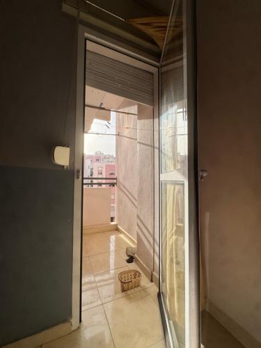 a glass door leading into a room with a balcony at Perfect Stay Apartment 10 min to airport ibn battouta and beach in Tangier