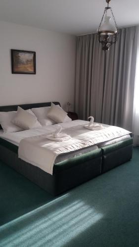 a bedroom with a large bed with white sheets at Hotel Zámeček Pod Hradem Starý Jičín 111 in Starý Jičín
