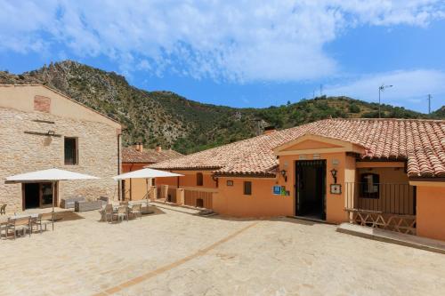 a group of buildings with tables and umbrellas at Hotel de La Trucha in Villarluengo