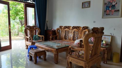 a living room with wooden chairs and a table at Tay Na Bon Homestay in Ha Giang