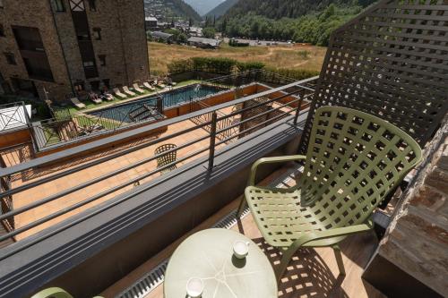 a balcony with two chairs and a table at Hotel Princesa Parc Excellence in Arinsal