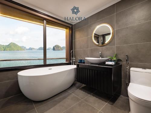 a bathroom with a tub and a sink and a window at Halora Kairos Cruise in Ha Long