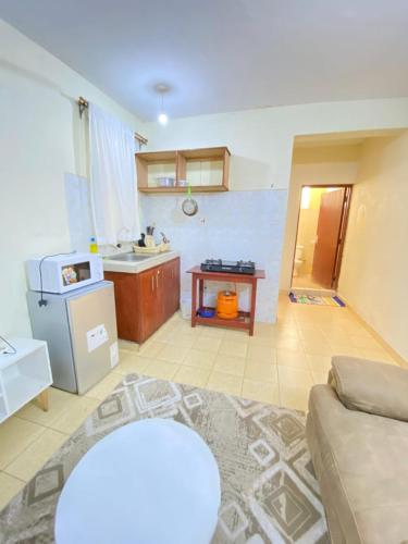 a living room with a couch and a kitchen at Lex homes in Mombasa