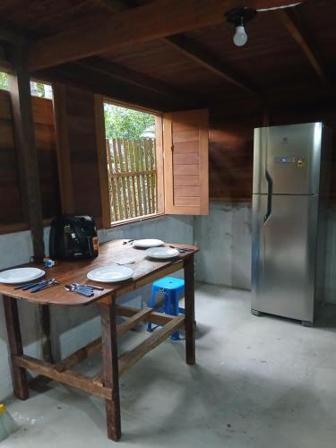 eine Küche mit einem Holztisch und einem Kühlschrank in der Unterkunft Altér Chale in Santarém