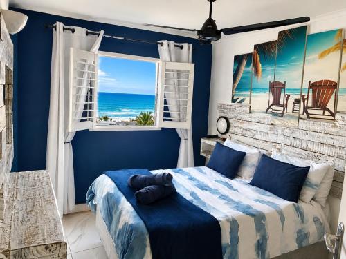 a bedroom with a bed and a window with the ocean at Chakas Cove in Ballito