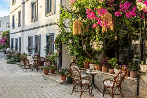 a street with chairs and tables and flowers at Kaya Apart Datca in Datca