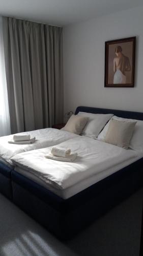 a bedroom with a bed with two towels on it at Hotel Zámeček Pod Hradem Starý Jičín 111 in Starý Jičín