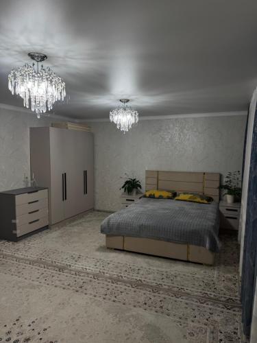 a bedroom with a bed and chandeliers in it at У Назгули in Cholpon-Ata