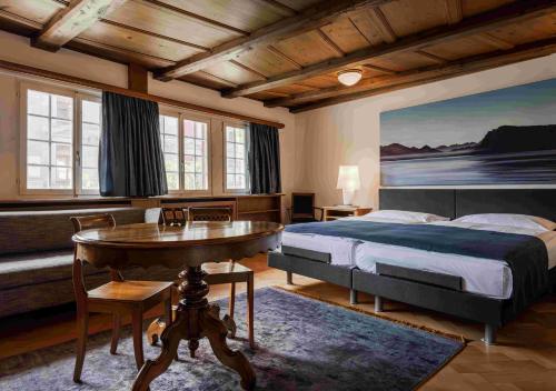 ein Schlafzimmer mit einem Bett, einem Schreibtisch und einem Tisch in der Unterkunft Hotel Rebstock in Luzern