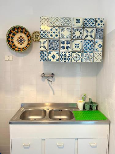 a kitchen with a sink and blue and white tiles at Casetta San Menaio in San Menaio