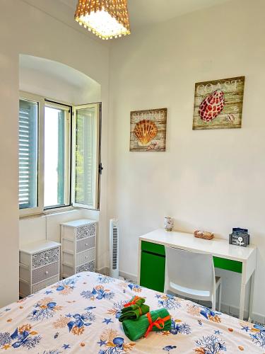 a bedroom with a bed and a desk and a table at Casetta San Menaio in San Menaio