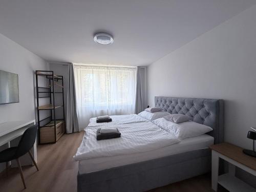 a bedroom with a large bed and a desk at Apartman H4 in Žilina