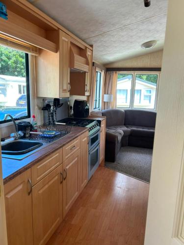 a kitchen with a stove and a couch in a caravan at 31 Mobile Home Lemon Park Devon in Bickington
