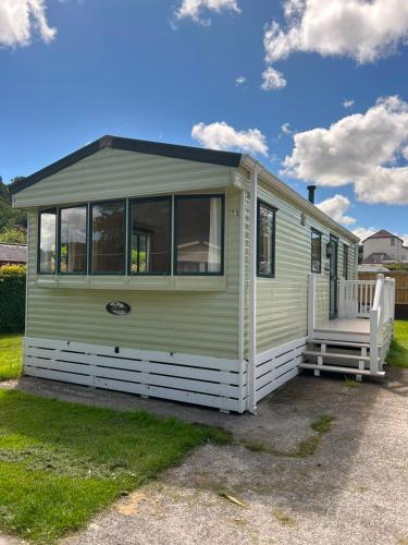 a green and white tiny house with a porch at 31 Mobile Home Lemon Park Devon in Bickington