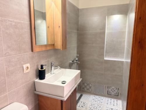 ein Badezimmer mit weißem Waschbecken und Dusche in der Unterkunft Mastic Nest in Chios