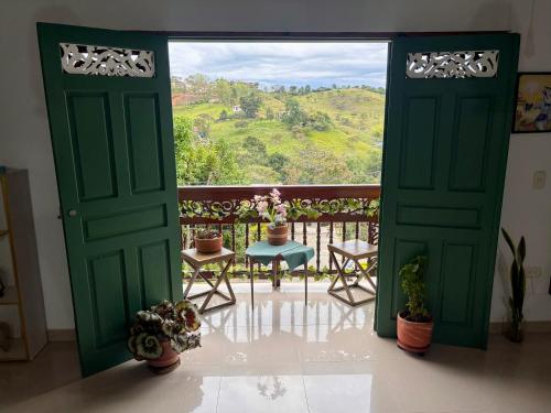 an open door to a balcony with a view at Blomst Casa Hostal in Jericó