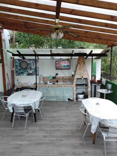 two tables and chairs on a patio with a kitchen at Елиани in Gabrovo