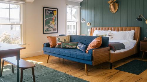a bedroom with a blue couch and a bed at Camp DeForest in Lincolnville