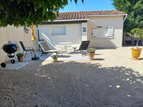 a patio with chairs and a grill in front of a house at Bienvenue en Provence in Monteux