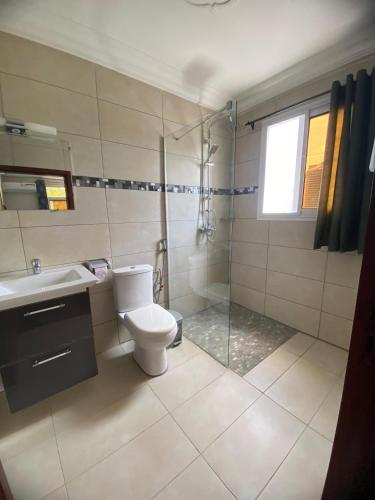 a bathroom with a toilet and a glass shower at Résidence les Palaja in Douala