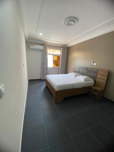 a bedroom with a bed and a window at Résidence les Palaja in Douala