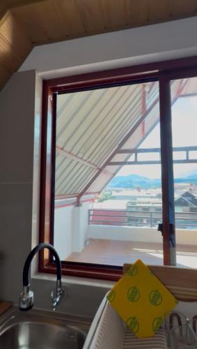 a sink and a window with a view of a train at La Casita de Merme in Oxapampa