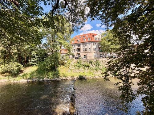 a large building sitting on the side of a river at aappartel APARTHOTEL Herford in Herford
