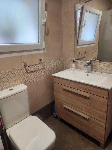 a bathroom with a toilet and a sink and a mirror at Apartamento Riberuca Playa in Suances