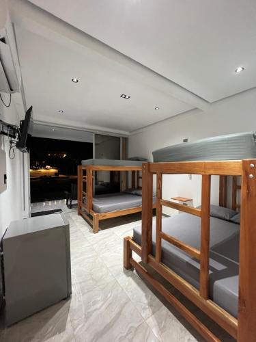 a room with three bunk beds and a television at Hotel Magic Capurganá in Capurganá