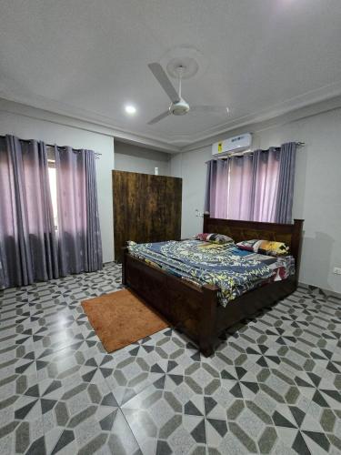 a bedroom with a bed and a ceiling fan at 2 bedroom super cozy apartment in Accra