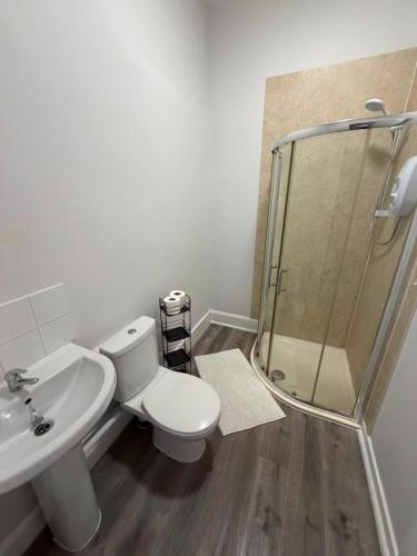 a bathroom with a shower and a toilet and a sink at Stylish Bolton Stay Parking Walk to Town Centre in Farnworth