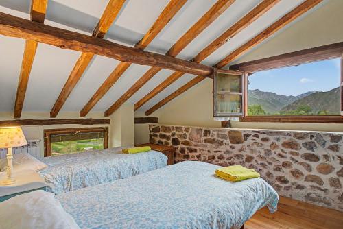 two beds in a room with a stone wall at Casa Del Tesoro in Triongo