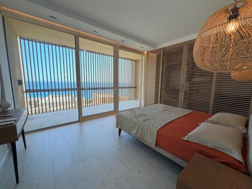 a bedroom with a bed and a large window at Villa Azul in Palasë