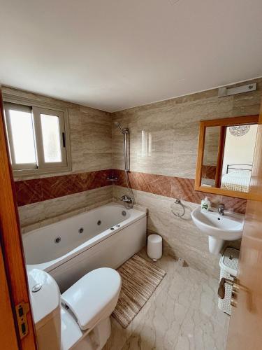 a bathroom with a tub and a toilet and a sink at Leda Beach Villa in Polis Chrysochous