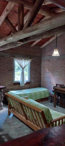 a large room with a bed and a window at Cabañas Rio de Oro in Mina Clavero