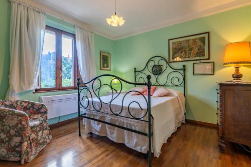 a bedroom with a bed and a chair and a window at CASALE LE CONCE 6, Emma Villas in Castel del Piano