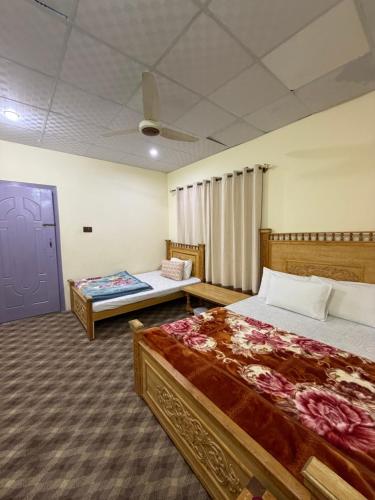 a bedroom with two beds and a blue door at MANOKUR - E- BASA HOTEl in Minapin