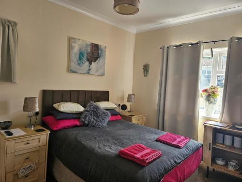 a bedroom with a bed with pink pillows on it at Shalom, in Saundersfoot, near the sea in Saundersfoot
