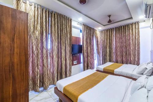 a hotel room with two beds and curtains at Hotel Sky in Dwarka