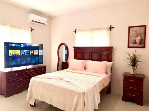 a bedroom with a bed and a flat screen tv at Olive Breeze III in Runaway Bay