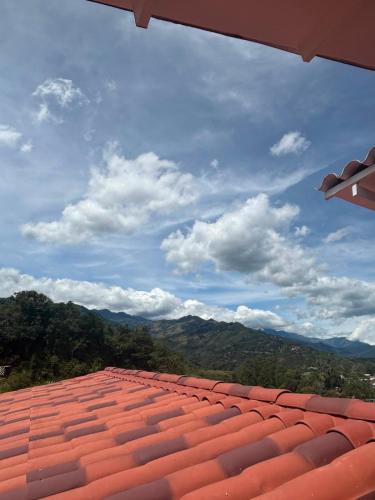 a view of a red tile roof with mountains in the background at Hotel Tumbaga 88 in Salento