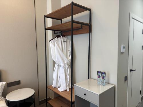 a room with a closet with a white shirt on a shelf at Wind Rose in Almaty